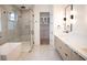 Bright bathroom featuring dual sinks, a glass shower, modern fixtures, and tile flooring at 5017 W Dickens Ave, Tampa, FL 33629