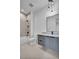 Modern bathroom with gray vanity, granite countertop, shower-tub, and stylish pendant lighting at 5017 W Dickens Ave, Tampa, FL 33629