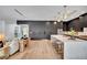 Modern kitchen with a long island, sleek black cabinets, and bar stool seating, with an open view to the living space at 5017 W Dickens Ave, Tampa, FL 33629
