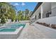 Stunning swimming pool and spa with modern architecture, palm trees and travertine pavers at 5017 W Dickens Ave, Tampa, FL 33629