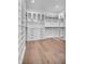 Well-organized walk-in closet featuring custom shelving, drawers, and ample storage space with hardwood floors at 5017 W Dickens Ave, Tampa, FL 33629