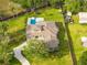 Aerial view of a luxury home featuring lush greenery, a swimming pool, and ample outdoor space at 5546 Drexel Rd, Land O Lakes, FL 34638