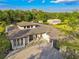 Aerial view of the gorgeous property with lush landscaping, a large driveway, and a modern home design at 5546 Drexel Rd, Land O Lakes, FL 34638