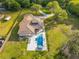 Expansive aerial view showcases the estate, pool, lush grounds, a winding drive, and mature trees at 5546 Drexel Rd, Land O Lakes, FL 34638