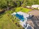 Aerial shot of a backyard oasis with a pool, slide, lounge chairs, palm trees, and spacious lawn at 5546 Drexel Rd, Land O Lakes, FL 34638