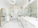 This primary bathroom is all white with gold fixtures and has a glass enclosed shower at 5546 Drexel Rd, Land O Lakes, FL 34638