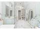 This all white bathroom has marble walls and floors, gold fixtures, and lots of storage space at 5546 Drexel Rd, Land O Lakes, FL 34638