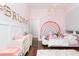 Cozy bedroom features pink walls, rainbow decor and natural light at 5546 Drexel Rd, Land O Lakes, FL 34638