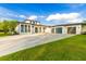 Contemporary home featuring a white exterior, black trim, large driveway, and three-car garage at 5546 Drexel Rd, Land O Lakes, FL 34638
