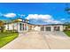 Beautifully designed modern home with a pristine white exterior, dark trim, and a spacious three-car garage at 5546 Drexel Rd, Land O Lakes, FL 34638