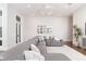 Modern living room with gray sectional sofa, decorative mirrors, and stylish lighting at 5546 Drexel Rd, Land O Lakes, FL 34638