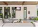 Cozy covered patio with comfortable seating, potted plants, and a mounted flatscreen TV at 5546 Drexel Rd, Land O Lakes, FL 34638