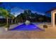 Twilight view of an inviting pool with a waterslide, surrounded by mature trees and lounge chairs at 5546 Drexel Rd, Land O Lakes, FL 34638
