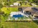 Aerial perspective of the pool, with a slide, lounge seating, and tropical landscaping in a generous backyard at 5546 Drexel Rd, Land O Lakes, FL 34638