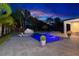 Backyard with swimming pool at dusk with LED lighting and lush tropical landscaping at 5546 Drexel Rd, Land O Lakes, FL 34638