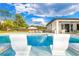 Luxury swimming pool with lounge chairs in the water and tropical landscaping at 5546 Drexel Rd, Land O Lakes, FL 34638