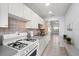 Galley kitchen with white appliances and tile backsplash at 5969 Terrace Park N Dr # 203, St Petersburg, FL 33709