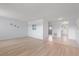 Open living room with light walls, wood floors, and tile entryway to kitchen at 5969 Terrace Park N Dr # 203, St Petersburg, FL 33709