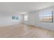 Spacious living room with wood floors, neutral walls, and a window with blinds at 5969 Terrace Park N Dr # 203, St Petersburg, FL 33709