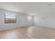 Bright living room with natural light, wood floors, a white door, and three mirrors at 5969 Terrace Park N Dr # 203, St Petersburg, FL 33709