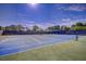 Well-maintained community tennis court with pristine blue and green surface and enclosed by mature landscaping and fencing at 5969 Terrace Park N Dr # 203, St Petersburg, FL 33709