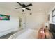 Bright bedroom features a ceiling fan, white walls, wood-look floors, and ensuite bathroom at 6321 La Brea St, North Port, FL 34287