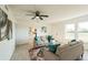 Bright living room features modern decor, light colored walls, ceiling fan, and a view into the kitchen at 6321 La Brea St, North Port, FL 34287