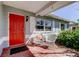 Charming front porch with brick flooring, a bright red front door, and cozy seating area at 6435 43Rd N Ave, Kenneth City, FL 33709