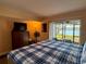 Comfortable bedroom with a plaid comforter and a sliding door with a beautiful water view at 7138 E Bank Dr # 7138, Tampa, FL 33617