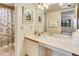 Bathroom with a shell-themed shower curtain and vanity with sink at 7564 Bayshore Dr # 207, Treasure Island, FL 33706