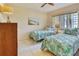 Bedroom furnished with twin beds with a lamp and palm-themed bedding at 7564 Bayshore Dr # 207, Treasure Island, FL 33706