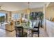 Bright dining room with a glass table, stylish chairs, and a view of lush outdoor scenery at 7564 Bayshore Dr # 207, Treasure Island, FL 33706