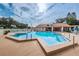 Outdoor swimming pool area with lounge chairs, blue skies and lush green landscaping at 1020 Bowsprit Ln # X, Holiday, FL 34691