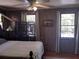 Comfortable bedroom featuring wood-paneled walls, two windows and decor at 1044 Virginia Dr, Sarasota, FL 34234