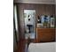 View of a bedroom leading to a bathroom with wood paneling and a decorative dresser at 1044 Virginia Dr, Sarasota, FL 34234