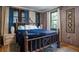Bedroom with warm wood walls, elegant bed, and natural light at 1044 Virginia Dr, Sarasota, FL 34234