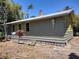 Side view of home with light green siding, yellow trim, and a sturdy brick chimney at 1044 Virginia Dr, Sarasota, FL 34234