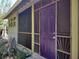 Home exterior featuring a screened porch and a brightly colored purple front door at 1044 Virginia Dr, Sarasota, FL 34234