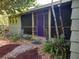 Charming home with a screened-in porch, vibrant purple door, and unique tiki decorations at 1044 Virginia Dr, Sarasota, FL 34234
