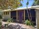 Charming home featuring a cozy screened front porch and a vibrant purple front door at 1044 Virginia Dr, Sarasota, FL 34234