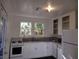 Well-lit kitchen features bright white cabinets, appliances and natural light from the windows at 1044 Virginia Dr, Sarasota, FL 34234