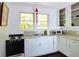 Bright kitchen with white cabinets, black appliances, and views to the backyard at 1044 Virginia Dr, Sarasota, FL 34234