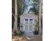 Charming outdoor shed featuring double doors, white trim, surrounded by lush landscaping at 1044 Virginia Dr, Sarasota, FL 34234
