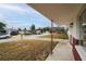 Exterior view of the home featuring a covered porch and a glimpse of the surrounding neighborhood at 1109 Landau St, Holiday, FL 34690