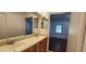 Bathroom with a double vanity and views into an adjacent bedroom at 11722 Currie Ln # E1, Largo, FL 33774