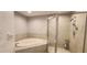 Bathroom featuring a soaking tub and a glass-enclosed shower at 11722 Currie Ln # E1, Largo, FL 33774