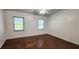 Spacious bedroom featuring rich hardwood floors and ample natural light from two windows at 11722 Currie Ln # E1, Largo, FL 33774