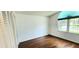 Clean bedroom with a large window, hardwood floors, and a closet at 11722 Currie Ln # E1, Largo, FL 33774