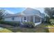 The back exterior of the house features a cozy enclosed porch and neat landscaping at 11722 Currie Ln # E1, Largo, FL 33774