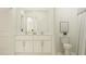 Bright bathroom featuring double sinks, a toilet, and modern finishes at 13035 Ruby Gold Ct, Wimauma, FL 33598